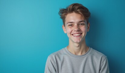 Cheerful young man smiling brightly against turquoise background with copy space