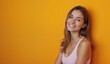 © Yury - Smiling woman with joyful expression against vibrant yellow background with copy space