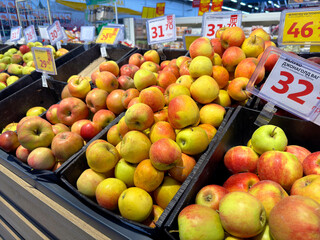 Apples are laid out in a supermarket. A stand with apples on a store counter. An apple on a shelf in a grocery store.