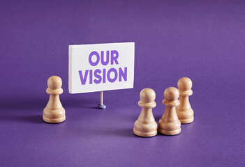 Chess pawns standing next to the banner with the message our vision.