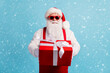 © deagreez - Portrait of his he nice attractive cheerful white-haired Santa father holding in hands big red bow ribbon gift December Eve Noel isolated bright vivid shine vibrant blue color background