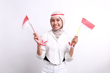 Excited young indonesian muslim girl holding red white flag while clenched hand. Isolated on white