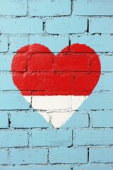 Poster - Colorful heart mural on a brick wall, featuring vibrant red and white colors against a soft blue background, symbolizing love and passion.
