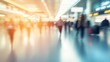 © olga_demina - Blurred travelers walking through a modern airport terminal. The image conveys a sense of movement and the busy atmosphere of air travel