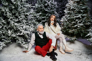 Wall Mural - A joyful moment features a man and a woman enjoying Christmas in a snowy wonderland.