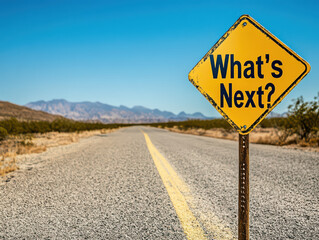 Yellow 'What's Next?' sign on a deserted road under a clear blue sky, symbolizing future possibilities and decisions.