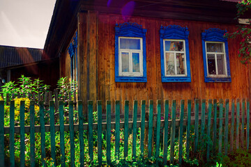 Old houses. Carved window frames. View of a fragment of a house wall with carved decorations around the window and doors. Traditional Russian old houses. Close-up. Front view. Landscape.