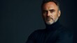 © Jittapon - Pensive and Reflective Portrait of a Middle aged German Man Dressed in a Minimalist Black Turtleneck Against a Plain Slate Background with Dramatic Lighting