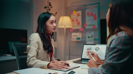 Aufkleber - Two businesswomen work late in the office, analyzing data on a laptop and digital tablet while discussing strategies for growth and planning future marketing initiatives