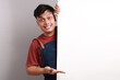 © ArvStd - Cheerful Asian man in apron presenting something on white advertisement board on white background