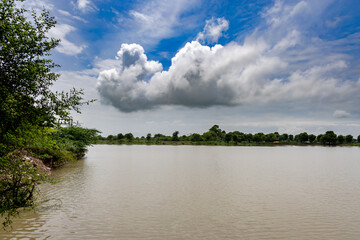 Flooded River Muddy Water with Bright blue Sky at morning