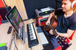 © princeoflove - asian male musician, producer playing acoustic guitar for recording in home studio