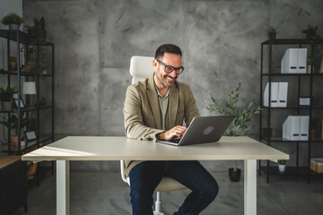 smile adult businessman work on new project on laptop in modern office