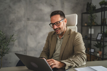 smile adult businessman work on new project on laptop in modern office