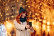 © Zamrznuti tonovi - Portrait of festive smiling girl taking selfies on street on new year.