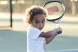 © romanets_v - Child playing tennis on court with racket under sunlight