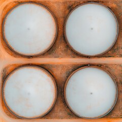 Aerial view of four large storage tanks in an industrial setting.