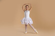 © New Africa - Little ballerina practicing dance moves on beige background