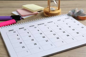 Timetable. Monthly planner and stationery on wooden table, closeup