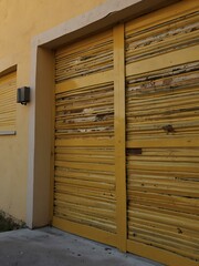 Opening a yellow iron shutter of a garage.