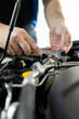 © zphoto83 - A mechanic repairs a car engine using a wrench in a clean workshop during daytime for quality maintenance work