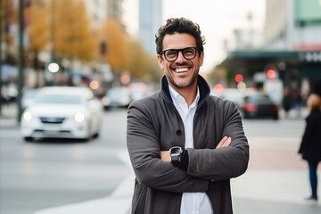 Portrait of a handsome young man with arms crossed in the city