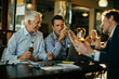 © Marko Geber - Businessmen celebrating success with drinks after work