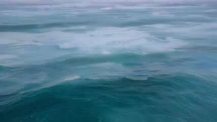 Aufkleber - Ocean waves are forming an abstract pattern. The water is a beautiful turquoise color, and the sky is a light blue with a few clouds
