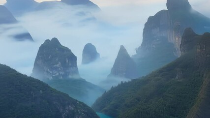 Poster - Surreal landscapes showcase a valley surrounded by steep mountains and dense fog, creating a mysterious atmosphere that captivates with its ethereal beauty