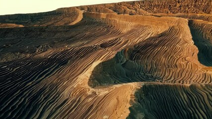 Poster - Camera movement reveals a surreal desert landscape featuring striking orange and black sand dunes. The scene captures the beauty of nature's erosion and wind formations in an arid environment