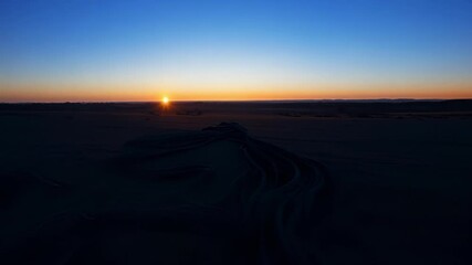 Poster - Surreal desert landscapes showcase a vibrant sun rising over the horizon, illuminating the vast expanse of sand with warm hues of orange, yellow, and red, creating a peaceful morning scene