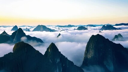 Poster - Series of captivating shots showcasing a mesmerizing view of misty clouds flowing over majestic mountain peaks, creating a surreal and dreamlike landscape