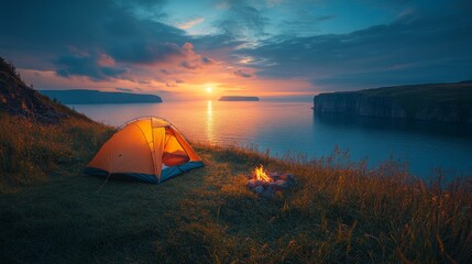 Fototapete - A tent sits near a serene body of water, surrounded by lush grass. A fire crackles beside it as the sun sets, casting a warm glow over the landscape.