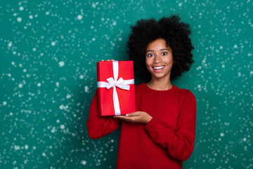 Photo of cute positive small schoolgirl wear red pullover buying christmas presents isolated green color background