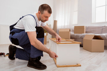 Fototapete - Professional Repairman Assembling Furniture Installing Shelf Working In Flat After Relocation, Wearing Blue Coverall. Carpentry Service