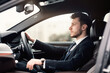 © Prostock-studio - Confident Businessperson. Side view portrait of handsome bearded young professional driving car in the city