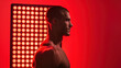 © ChimE - An athletic senior man stands proud in front of a glowing red light therapy panel, showcasing health and vitality in his space.