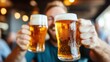 © Lens Legacy - A smiling man raises two mugs of frothy beer in a lively pub, evoking the cheerful atmosphere of social gatherings and celebrations with friends.