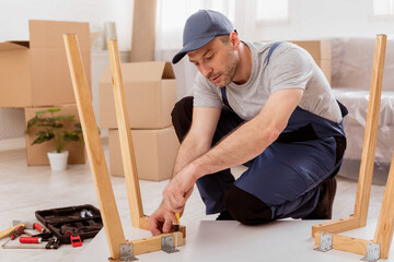Aufkleber - Professional Carpenter Working Assembling Desk Installing Furniture After Relocation Indoor. Furnishing New House.