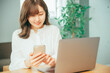© buritora - スマホとノートパソコンを使う女性