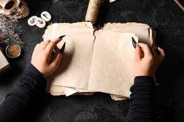 Witch with spell book on dark background