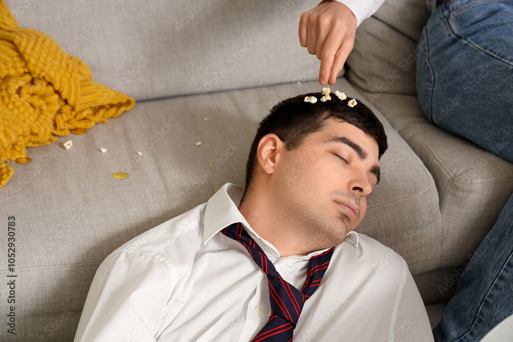 Drunk young man with popcorn sleeping after New Year party at home, closeup