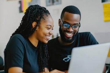 Two people looking at a laptop screen filled with charts and data, discussing and analyzing content together in a modern office setting.