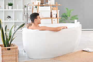 Wall Mural - Young man taking bath in room