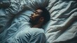 © Berkah - Young african-american man sleeping in bed top view.