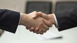 © Galib - Two people shaking hands in a business meeting.