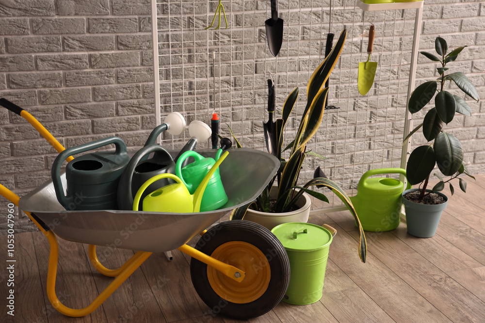 Pin board with gardening tools and plants near grey brick wall in workshop