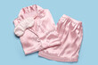 © Pixel-Shot - Stylish silk pajamas and sleeping mask on color background