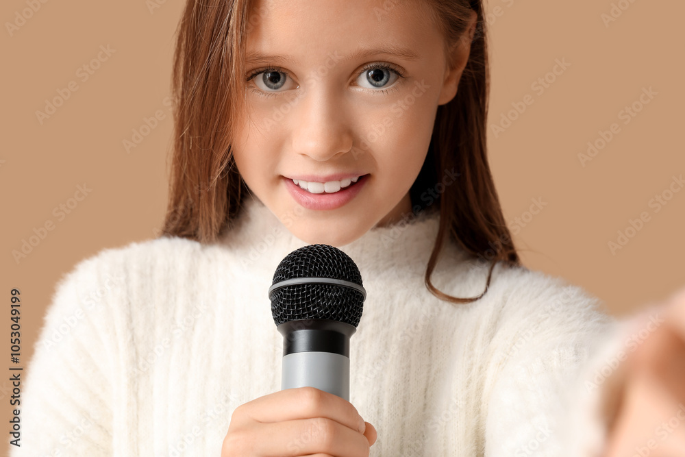 Cute girl with modern microphone on brown background, closeup