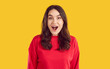 © Studio Romantic - Amazed wondered excited young brunette woman in red sweatshirt with opened mouth and wide opened eyes on yellow background. Sincere human emotions concept, banner for advertisement and marketing.